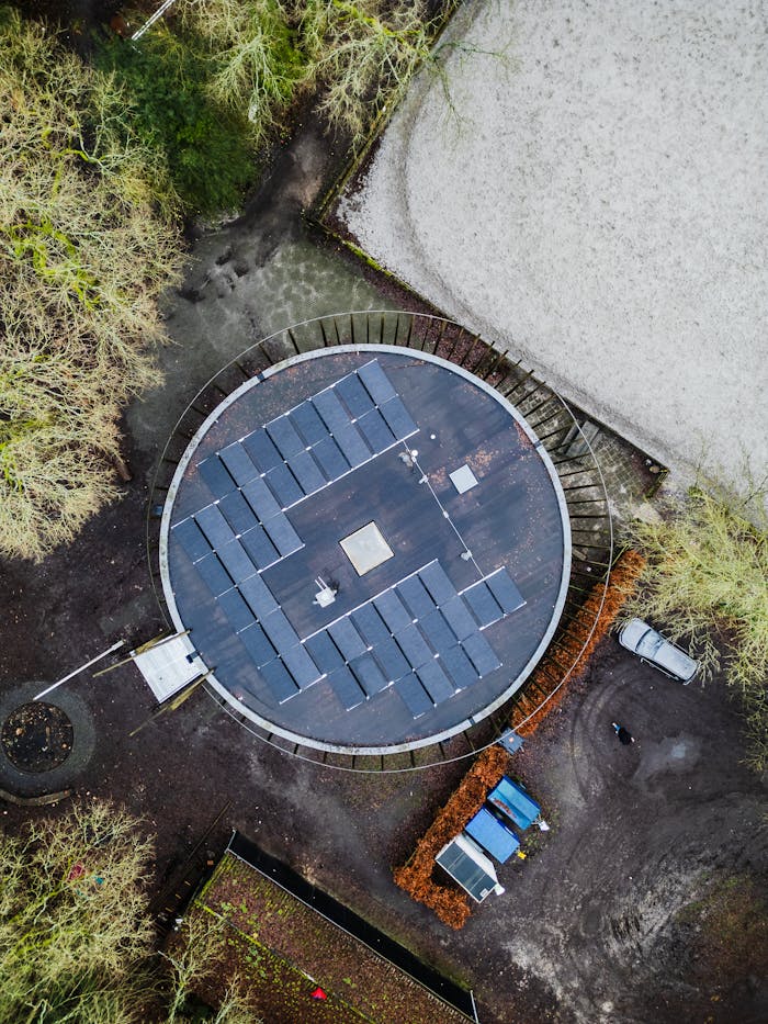 Crafting Captivating Headlines: Your awesome post title goes here Drone shot of a circular rooftop covered with solar panels surrounded by trees.