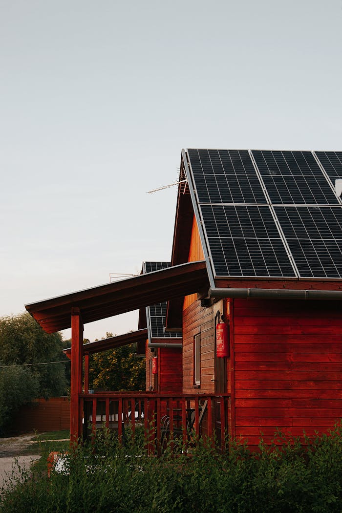 Services Wooden house featuring solar panels, captured at sunset, highlighting eco-friendly architecture.